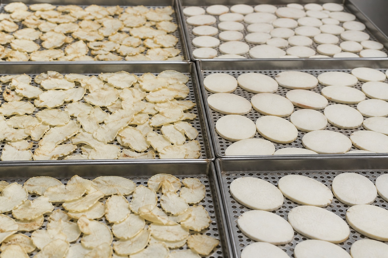 Cassava and root crop pieces arranged on trays for industrial drying